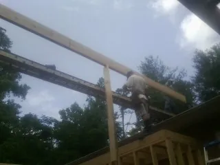 Carpenter setting a ridge beam over a new addition frame — Ice Dam Removal by Roofing Brothers in Montour