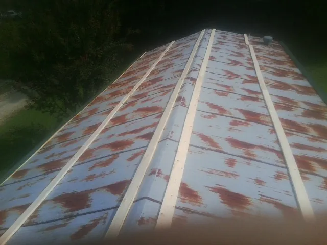 Rusted metal roof panels with new wood purlins before replacement — Storm Damage Roof Repair in Montour by Roofing Brothers