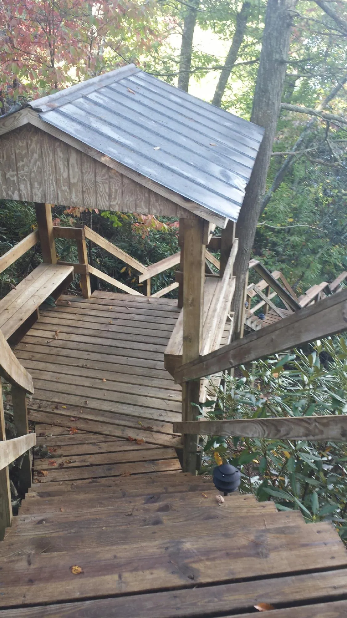 Metal roofed shelter over wooden steps on a wooded walkway — Skylight Repair & Installation work by our crew in Montour