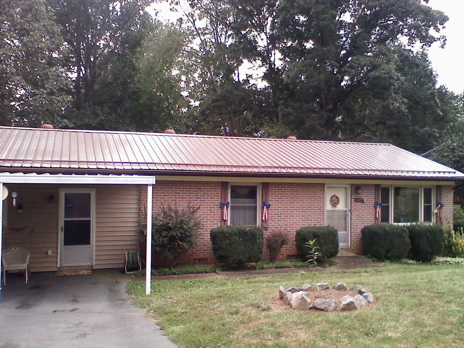 Bronze metal roof and carport on a brick ranch home — Roof Repair work by our crew in Montour